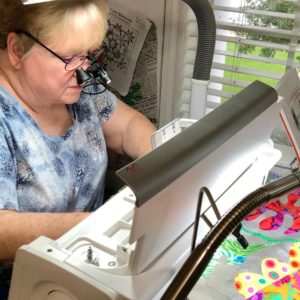 CraftOptics magnifying eyeglasses and light being used for machine quilting