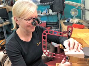 Silversmith Peggy Houchin working at her jeweler's bench wearing CraftOptics Magnifying Eyeglasses and DreamBeam Light.